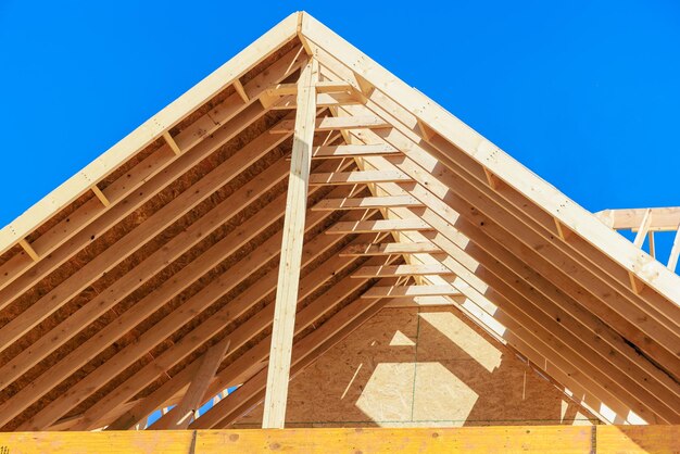 Framing of new residential construction home with a view of the roof