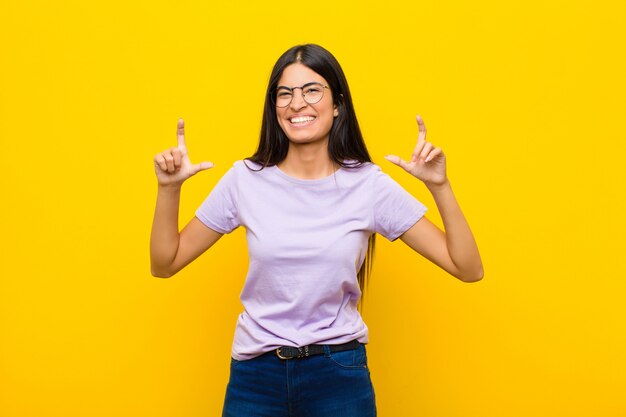 framing or outlining own smile with both hands, looking positive and happy, wellness concept