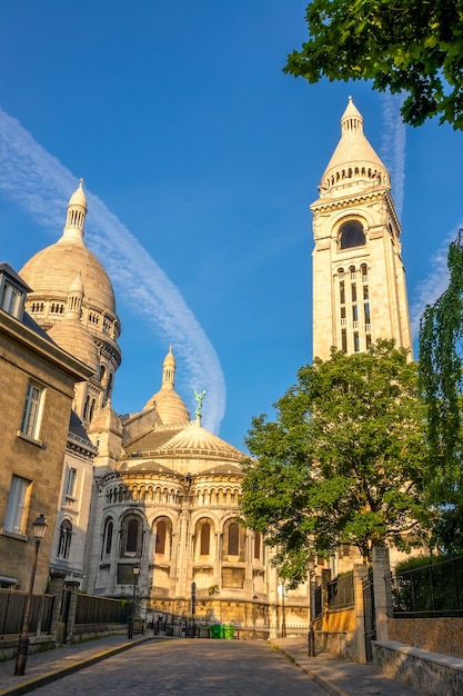 フランス。パリのモンマルトル地区。聖心大聖堂の空の通りと鐘楼。夏の晴れた日と青い空の奇妙な雲