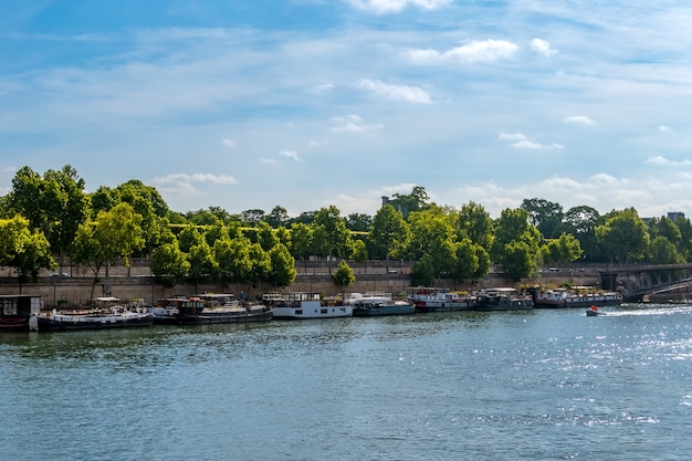France. Paris. Summer day. River Seine. Many houses on the water moored at granite embankments