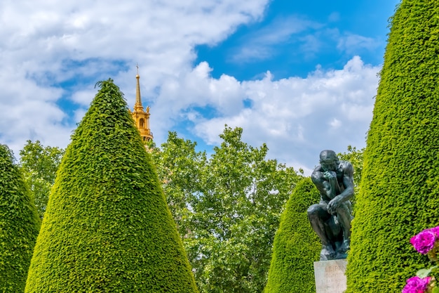 France. Summer sunny day at the Rodin Museum in Paris. Sculpture of a Thinker in a green garden