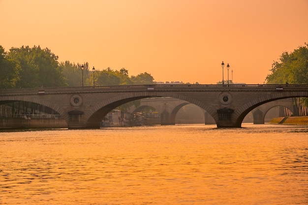 フランス。パリのセーヌ川に架かる夕日と石の橋