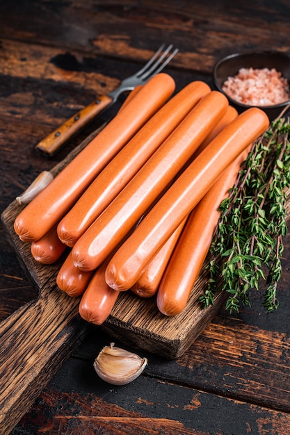 Frankfurter sausages on wooden cutting board