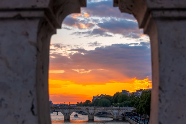 Frankrijk. Zomer zonsondergang over de rivier de Seine in Parijs. Uitzicht door het granieten hek van de brug