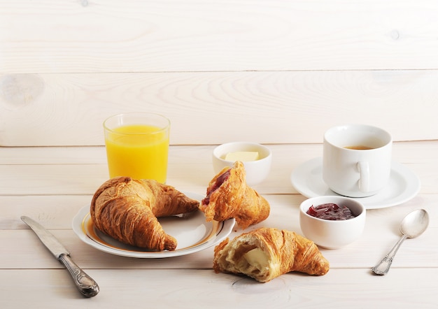 Frans ontbijt met croissant, jam, boter, jus d'orange en koffie