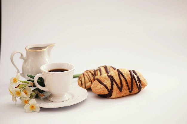 Frans ontbijt op tafel. koffiecroissant met chocolade en een karaf met room. vers gebak en cafeïnevrije koffie.