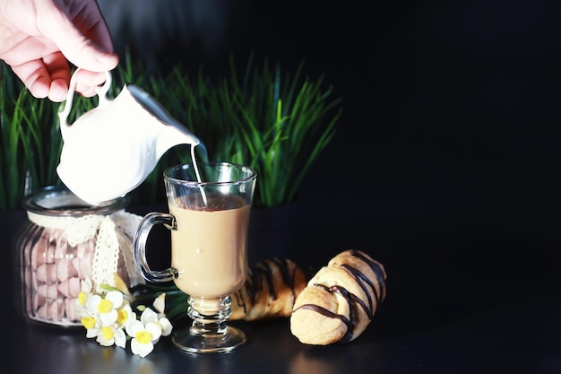 Frans ontbijt op tafel. Koffiecroissant met chocolade en een karaf met room. Vers gebak en cafeïnevrije koffie.