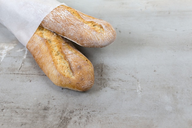 Frans stokbrood gebakken brood op grijze stenen tafelachtergrond milieuvriendelijke papieren verpakking