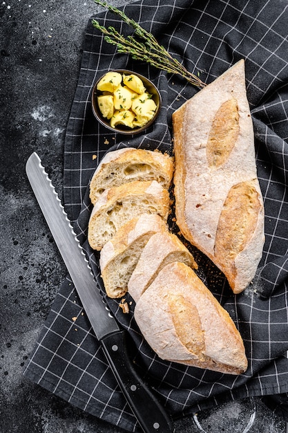 Frans stokbrood met boter voor het ontbijt. zwarte achtergrond. bovenaanzicht