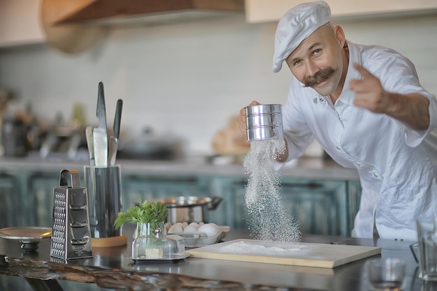 Franse chef-kok in de keuken die voedsel bereidt, koken, haute cuisine, man met snor