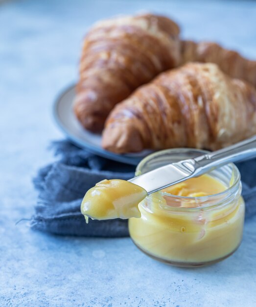 Franse croissant. Versgebakken croissants met honing op blauwe betonnen ondergrond.