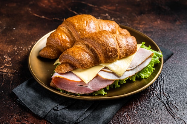 Franse croissantsandwich met sla, kaas, tomaten en ham Donkere achtergrond Bovenaanzicht