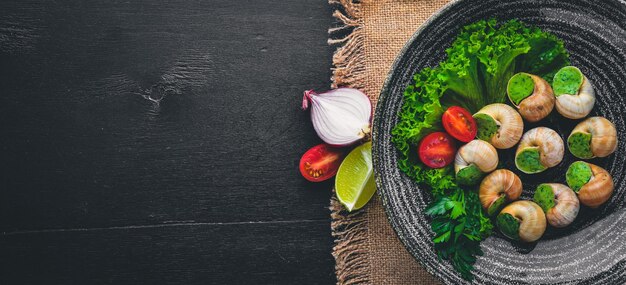 Franse en Italiaanse keuken Gebakken slakken Op een houten ondergrond Bovenaanzicht Vrije ruimte