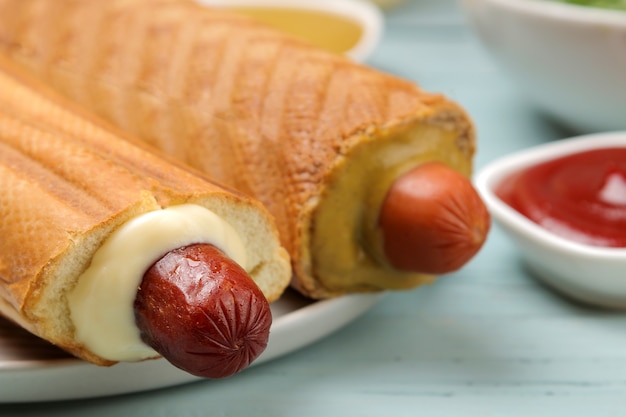 Franse hotdogs. Heerlijke hotdogs en ketchup op een lichtblauwe houten tafel. fastfood straatvoedsel. worstjes op een broodje.