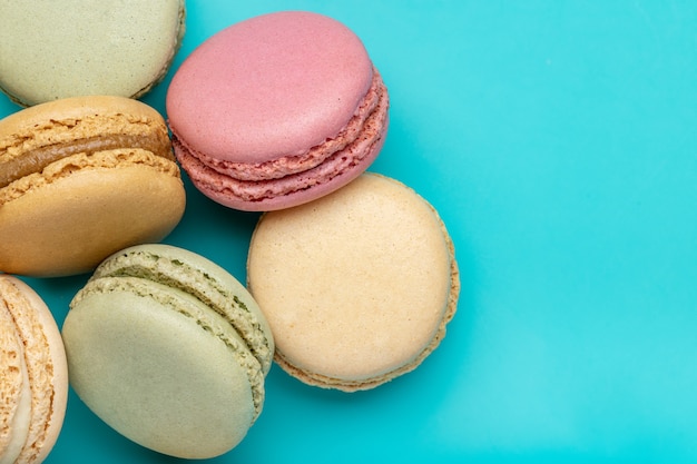 Franse koekjeskoekjes in verschillende kleuren Macarons close-up studio opname donkerblauwe achtergrond