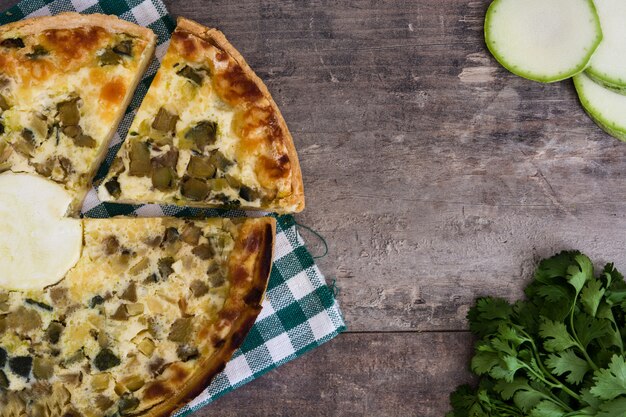 Franse quiche Lotharingen met groenten op houten tafel