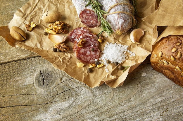 Franse salami en walnoten op ambachtelijk papier op houten achtergrond