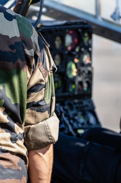 Foto franse soldaat met uniforme camouflagekleur close-up op zijn achterarm helikoptercockpit op de achtergrond