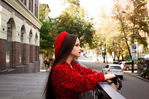 Foto franse vrouw in een rode baret kijkt in de verte