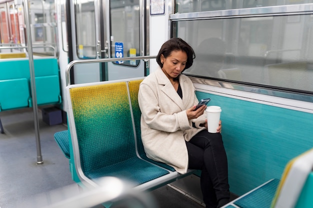 Franse vrouw rijdt in de metro en gebruikt haar smartphone