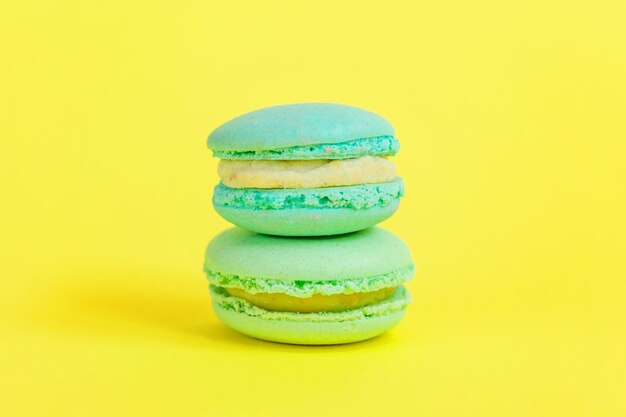 Franse zoete cookie minimale voedsel bakkerij concept blauwe macaron taart geïsoleerd op gele achtergrond