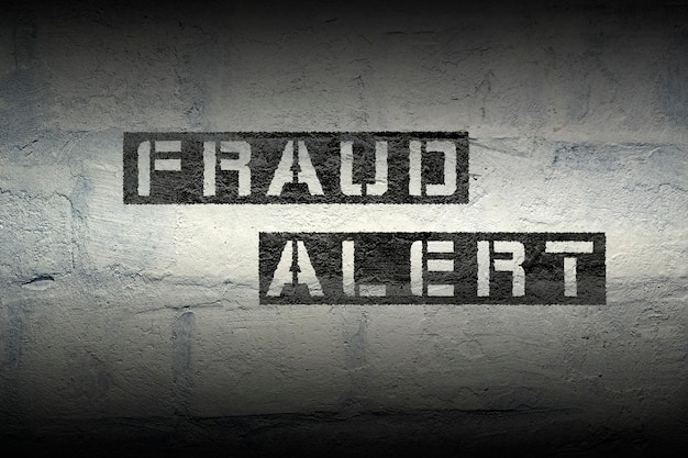 fraud alert stencil print on the grunge white brick wall