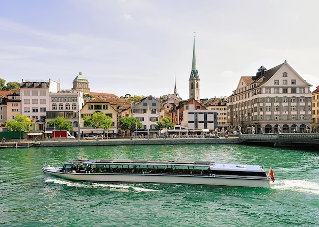 Fraumunster Church and ferry Limmat River quay in the city center of Zurich, Switzerland. People on the background