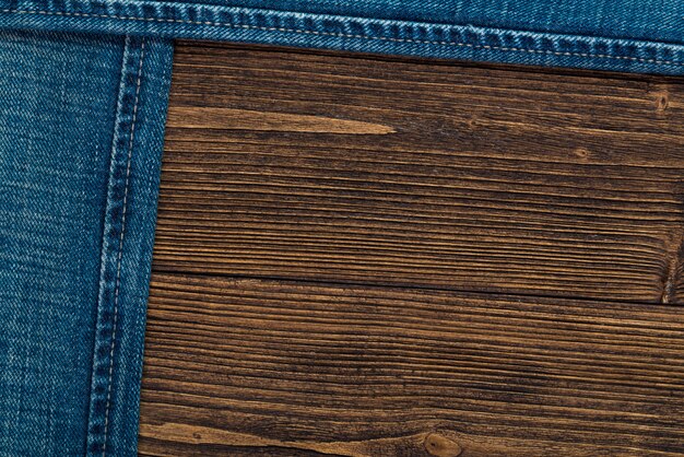 Frayed jeans or blue jeans denim collection on rough dark wood