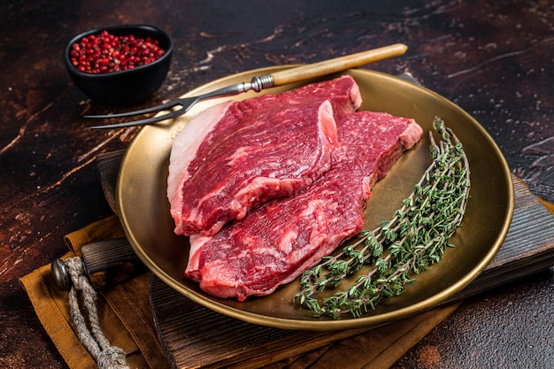 Freah Raw cap rump beef meat steak in a plate with thyme top sirloin steak Dark background Top view