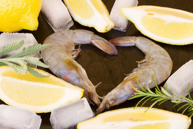 Freah  raw prawns with psices and ice on black background