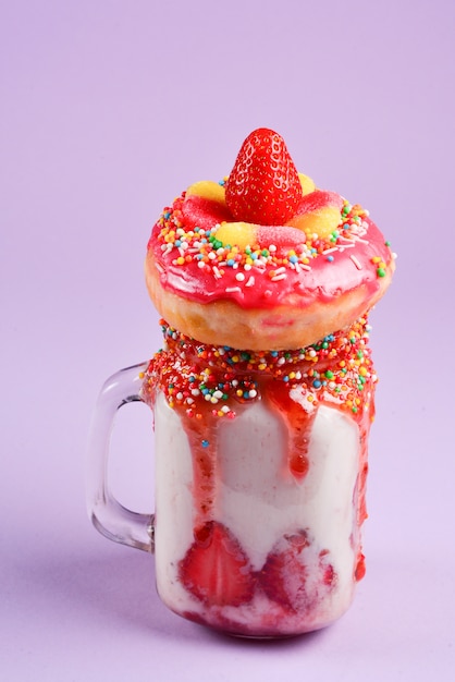 Freakshake. Extreme milkshake with strawberry, jelly sweets, donut.