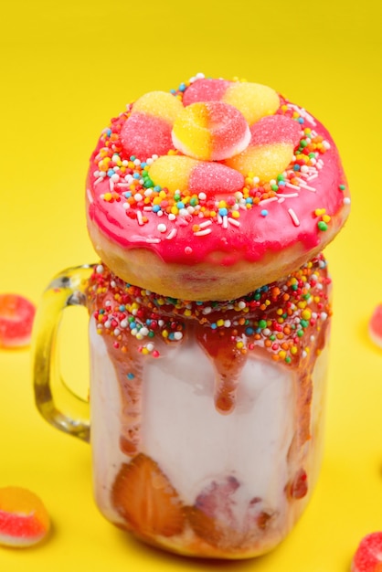 Freakshake. Extreme milkshake with strawberry, jelly sweets, donut.