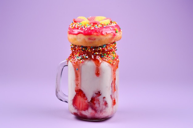 Freakshake. Extreme milkshake with strawberry, jelly sweets, donut.