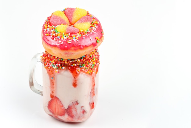 Freakshake. Extreme milkshake with strawberry, jelly sweets, donut.