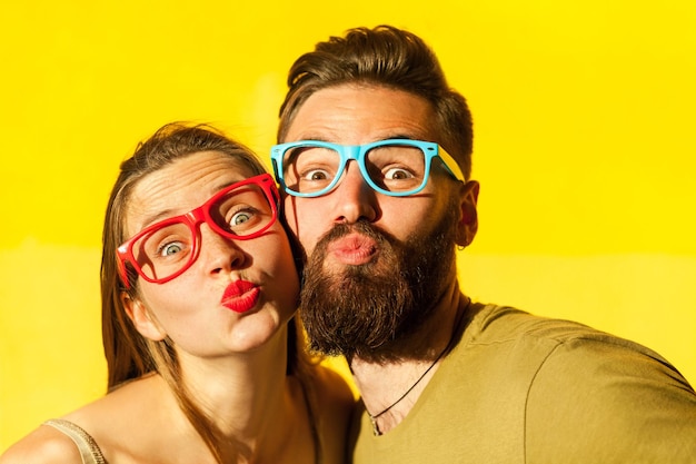 Freckled woman and bearded man send air kissing at camera