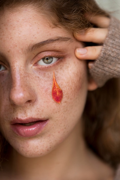 Photo freckled woman with leaves on her face