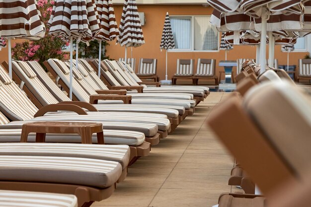 Photo free beach chairs with pillows and sun loungers are in a row