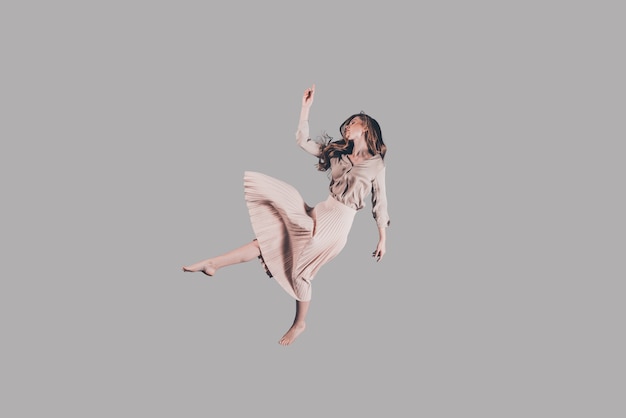 Free falling. Studio shot of attractive young woman hovering in air
