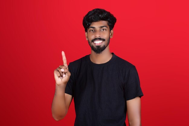 Free photo young male wearing black tshirt with a lifted one finger gesturing