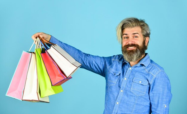 Free shipping. Bearded man hold shopping bags. Seasonal sale. Hipster buying sale price. Black Friday. Cyber monday sale. Boost sales. Profitable deals. Retail concept. Happy holidays. Handsome buyer.