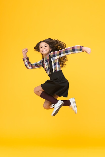 Free style Happy schoolchild in midair yellow background Free from school Summer holidays Free time All good things are wild and free