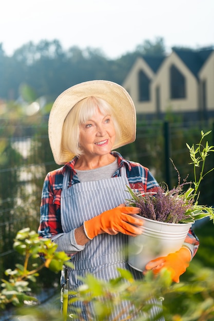 Free time. Smiling pretty old woman smiling while spending a day outside