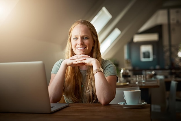 Бесплатный Wi-Fi делает мой день Снимок молодой женщины, использующей свой ноутбук в кафе