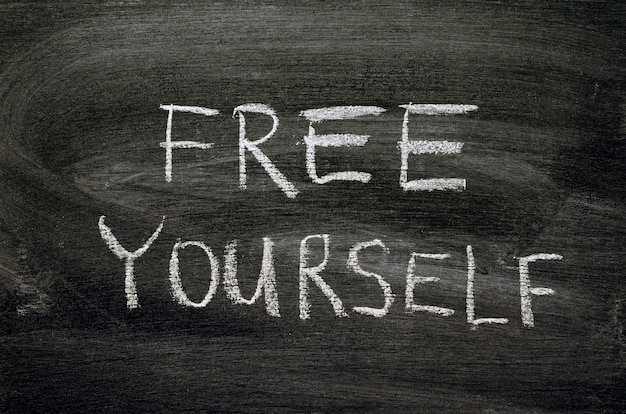 Free yourself phrase handwritten on school blackboard