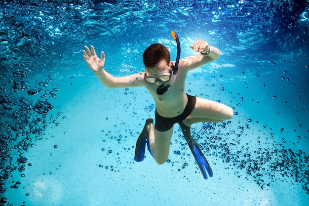 Freedive. Tiener in het masker en snorkel onderwater zwemmen.