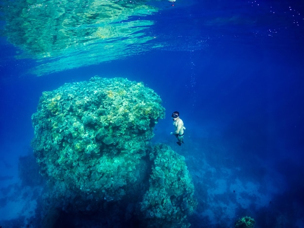 Freediver zwemmen in de buurt van koraalrif in de Rode Zee