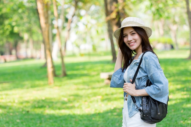 自由と発見のコンセプト：カジュアルでかわいいスマートなアジア人の女性が公園を歩いている