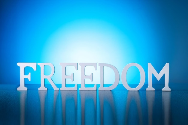 Photo freedom concept with freedom word on blue background.