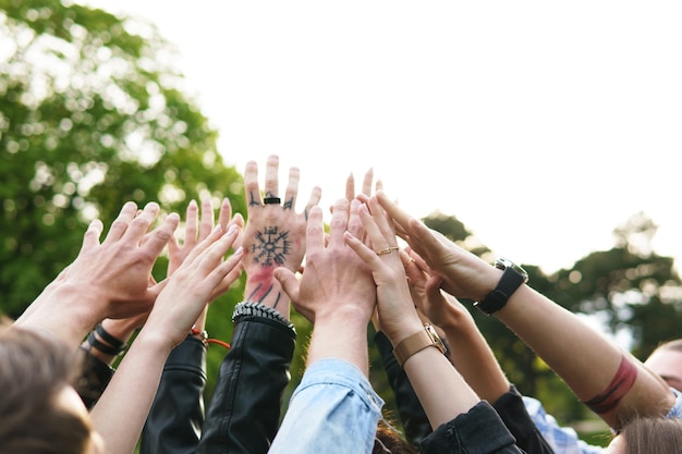 Photo freedom and friendship. group of young people putting hands up in the air.