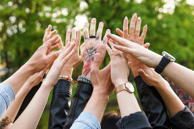 Freedom and friendship. Group of young people putting hands up in the air.